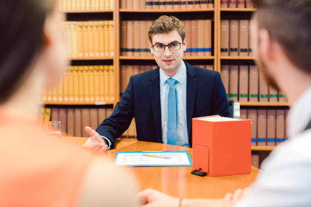 A court paralegal interpreter discussing documents with clients in a law library