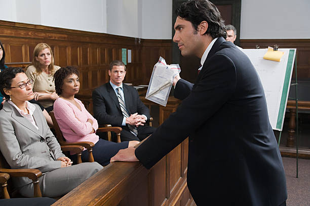 A lawyer speaks to jurors in a courtroom, with court interpreter services assisting