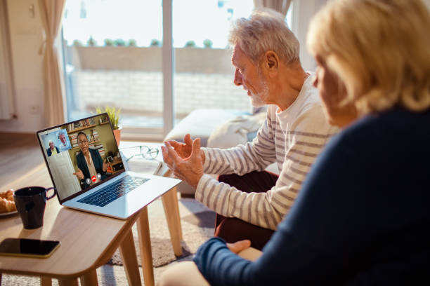 Elderly couple engaging with a virtual ASL interpreter on their laptop at homejpg