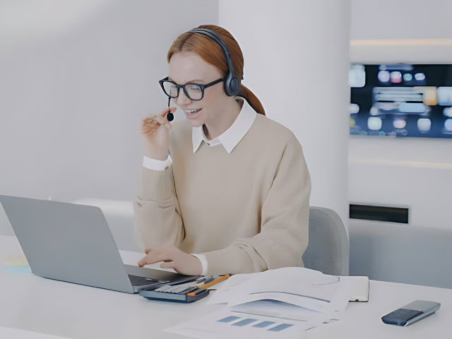 An interpreter delivering on call interpreting services via headset while working on a laptoppng